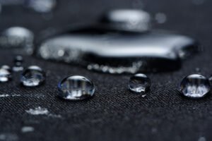 Gouttes d’eau sur tissu traité, démonstration de l’efficacité hydrophobe sans PFAS développée par H&B Materials